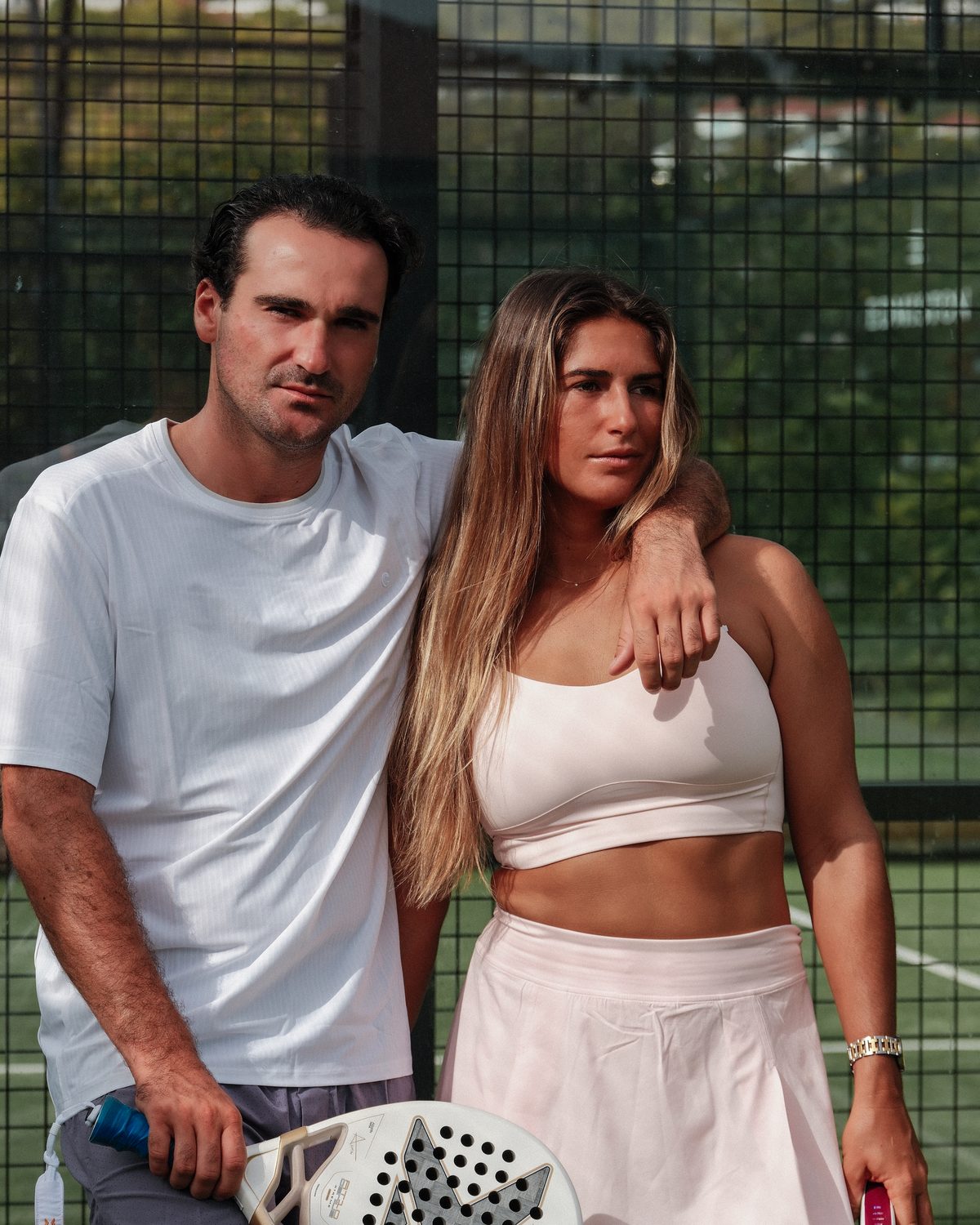 Deux joueurs en tenue claire devant le court